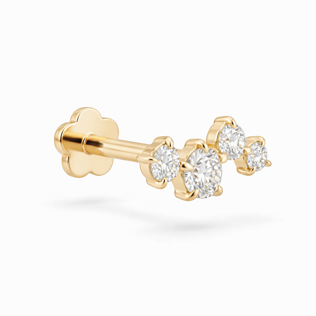 Gold earring with three clear gemstones on a white background