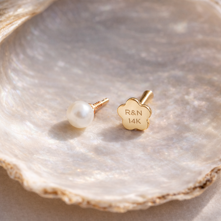 Gold pearl earring on a shell